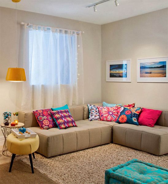 Sofá bege com almofadas coloridas de crochê