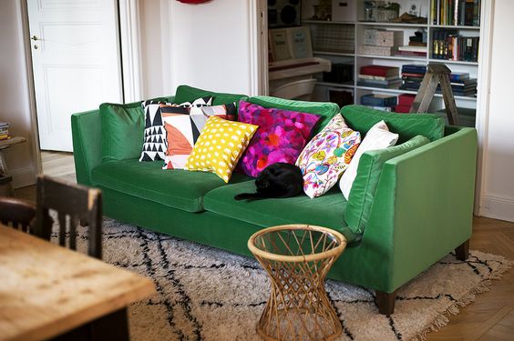 sofá verde com almofadas coloridas