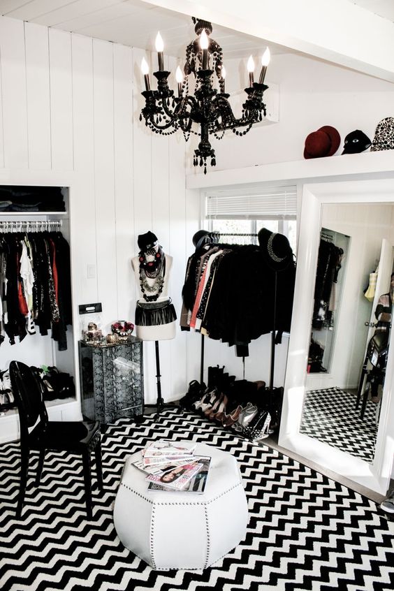 closet branco com tapete preto e branco, cadeira e lustre pretos
