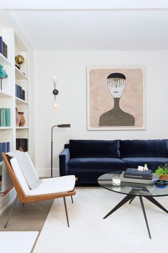 sofá azul com decoração e quadros