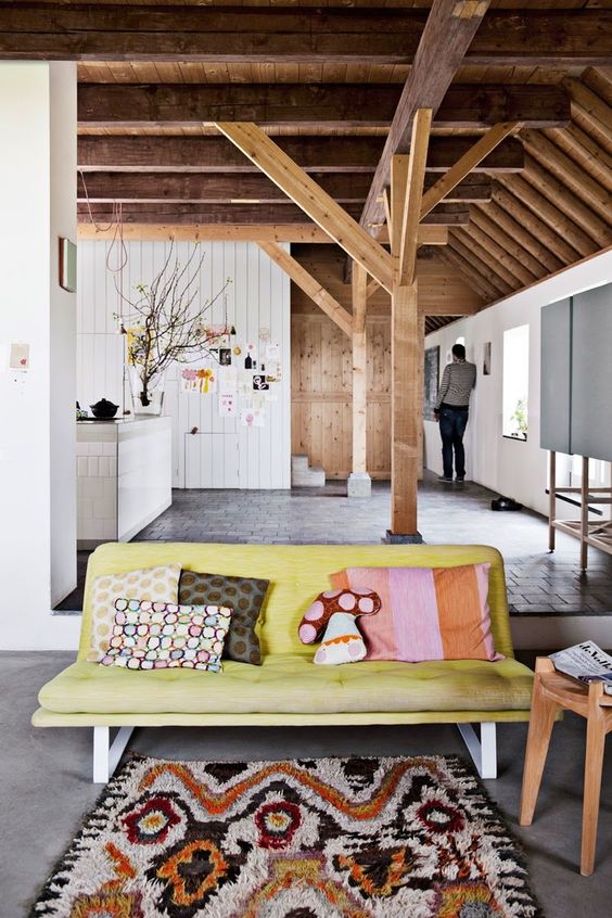 Casa de madeira decorada com sofá e almofadas coloridas