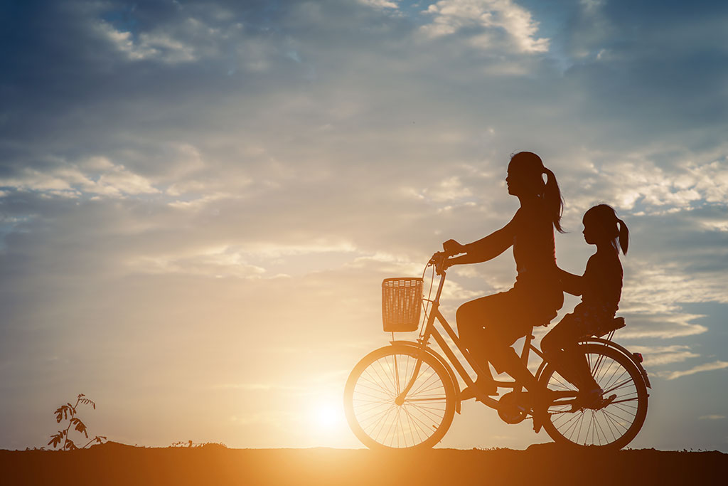 Mulher curtindo a vida andando de bicicleta com a filha